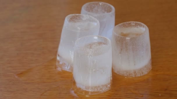 Sklenice z ledu s vodkou tání na stůl. časová prodleva. — Stock video