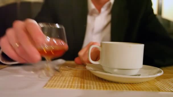 Mão de pessoa que toma de vidro de mesa de jantar com bebida — Vídeo de Stock
