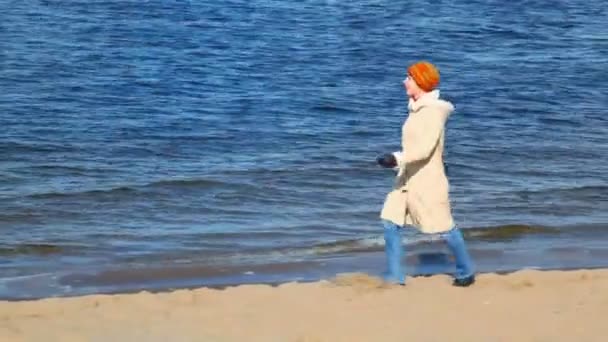 Kvinnan promenader längs sandstranden bank — Stockvideo