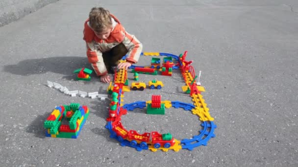 Boy plays plastic railway — Stock Video