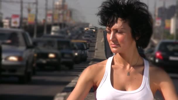 Girl sitting on highway middle in city — Stock Video