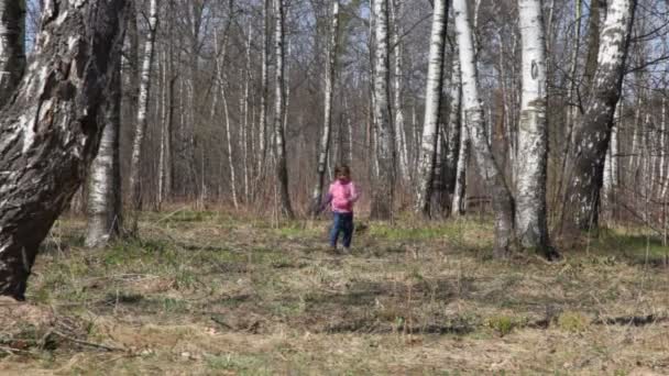 Roztomilá holčička vede k fotoaparátu v lese na jaře — Stock video