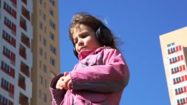 müzik dinleme ve kulaklık ile bahçede duran kız