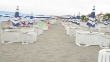 kamera hızlı bir şekilde hareket sahilde şezlong ve şemsiyeler arasında.