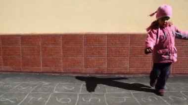 Resim seksek oyunu ile asfalt üzerinde dönen kız