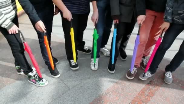 Men placed folded colored umbrellas on foot and stomp — Stock Video