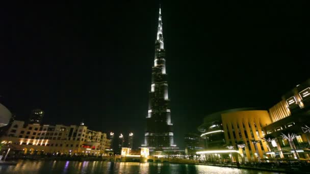 Burj Khalifa, el edificio más alto del mundo, y Burj Dubai Lake por la noche en Dubai, Emiratos Árabes Unidos . — Vídeo de stock