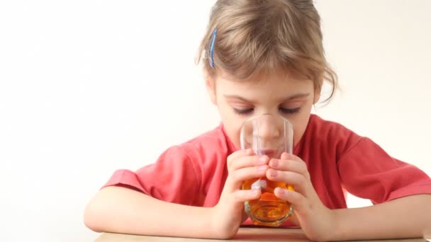 Κοριτσάκι πίνουν χυμό πορτοκαλιού και χαμογελαστός — Αρχείο Βίντεο