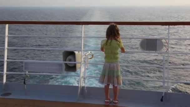 Girl stands aft of cruise liner and looks at sea — Stock Video