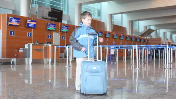 Boy at airport stands, then comes out — Stock Video