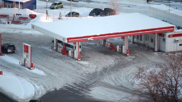 En invierno los coches de la ciudad repostan en la gasolinera — Vídeos de Stock