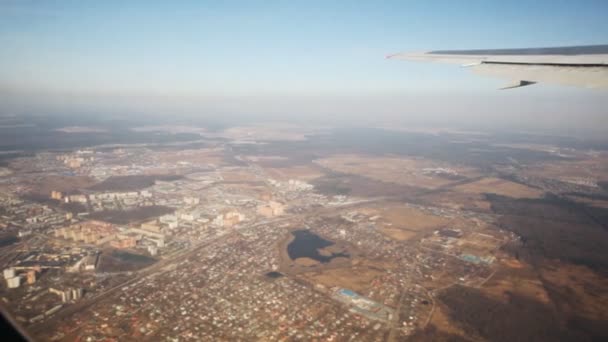 Vista dall'alto a città attraverso finestra di aereo volante — Video Stock