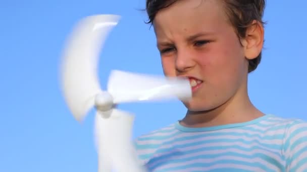 Мальчик держит в руках игрушечный ветрогенератор — стоковое видео