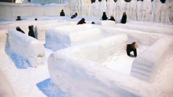Діти йдуть лабіринтом, зробленим повністю зі снігу — стокове відео
