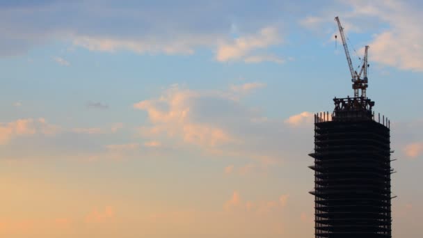 Het moderne gebouw is in aanbouw van de gestopd tegen zonsondergang hemel. — Stockvideo