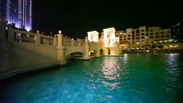 Stands on bridge near fountains in night Dubai city in Dubai, UAE — Stock Video