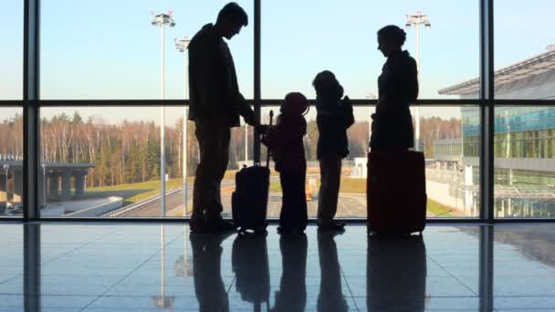 Família fica contra janela no aeroporto — Vídeo de Stock