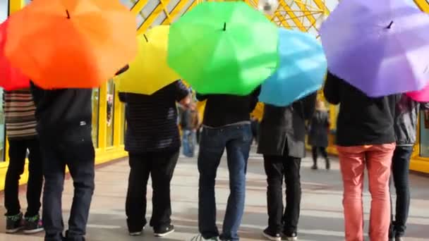 Homens jovens girar guarda-chuvas coloridos de volta para a câmera, em seguida, saltar para cima — Vídeo de Stock