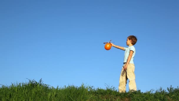 Junge beim Aufblasen und Ballwurf mit Luftschraube im Freien — Stockvideo