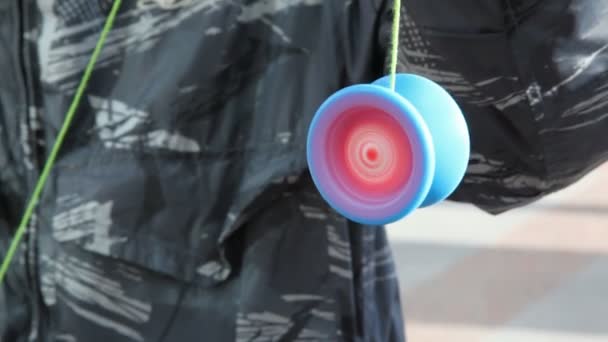 Ung man håller yoyo på snöre, och det snurrar snabbt — Stockvideo
