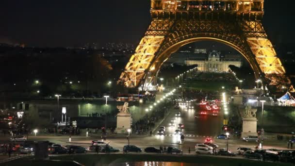 Autók a kereszteződésen alatt éjszaka eiffel torony megvilágítás, Párizs, Franciaország. — Stock videók