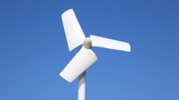 Winziger Windgenerator beginnt sich gegen den Himmel zu drehen — Stockvideo