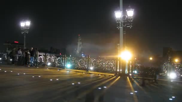 Caminar en el puente Patriarshy por la noche y la estatua de la estatua de Pedro el Grande en Moscú . — Vídeos de Stock