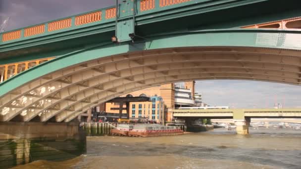 Visa från utflyktsbåt går långsamt under bron över floden thames — Stockvideo