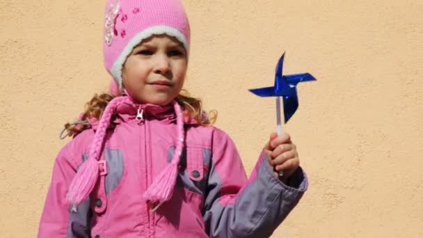 Girl holding toy windmill left hand — Stock Video