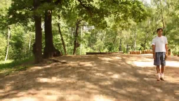 El hombre y la mujer se mueven en la plaza en el parque . — Vídeos de Stock