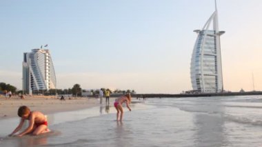 burj al arab beş yıldızlı otel yakınındaki plajda günbatımı sırasında oynayan çocuklar