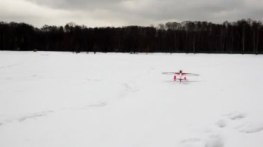 Toy radio-controlled plane flies up from snow