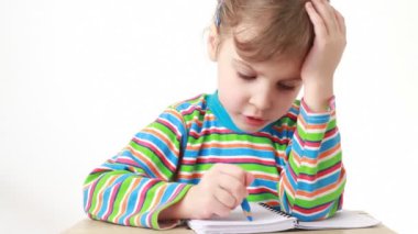 kalem ve defter ile masaya oturan şaşkın kız