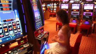 mujer en máquina tragamonedas en la sala de juegos en el Golfo Pérsico.