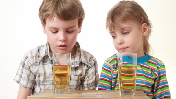 Niño y niña sentado y beber jugo — Vídeos de Stock