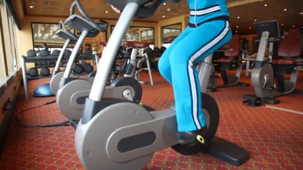 Pernas de mulher treinando em bicicleta de exercício — Vídeo de Stock