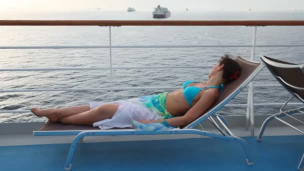 Femme allongée sur un transat sur le pont — Video