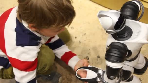 Boy plays with radiocontrol toy robot — Stock Video