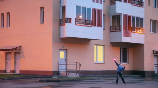 Boy plays with hand gear propeller near apartment house — Stock Video