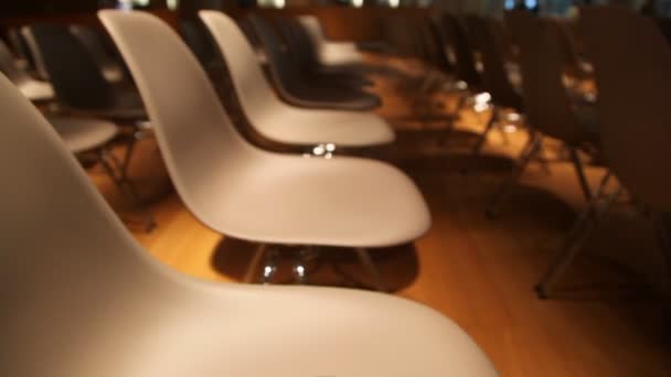 Vista se mueve de muchos a una silla con comunicador en la parte superior en la sala de conferencias — Vídeos de Stock