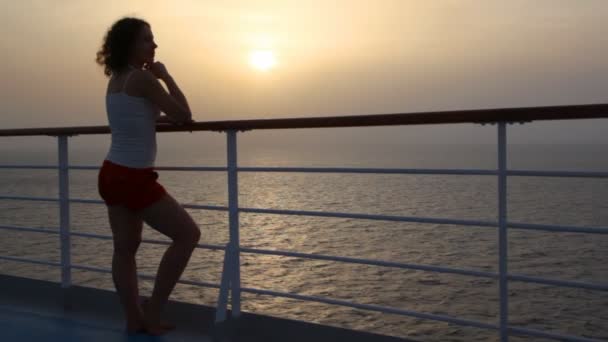 Frau steht auf Deck von Kreuzfahrtschiff und blickt aufs Meer — Stockvideo