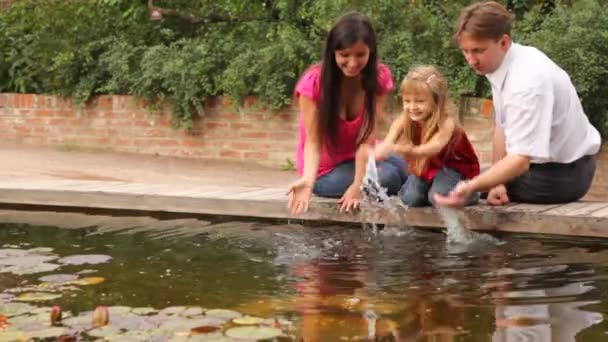 Familie makifamily lässt Wasser nahe Pfund plätschern — Stockvideo