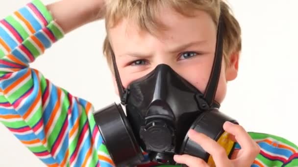 Pojken sätter på respirator och ser på kameran — Stockvideo