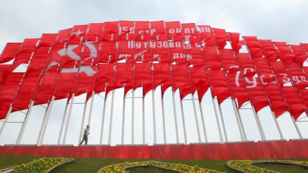 Menino caminha contra enormes bandeiras vermelhas comunistas — Vídeo de Stock
