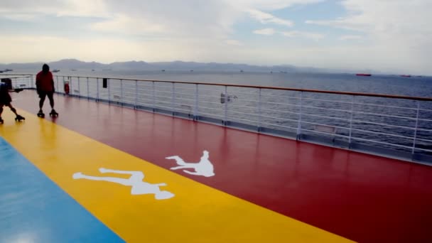 Touristes promenades sur patins à roulettes sur le pont du bateau de croisière — Video