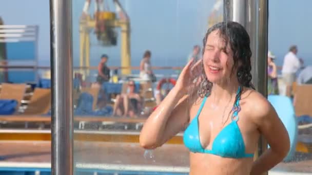 Mujer tomando una ducha cerca de la piscina — Vídeos de Stock