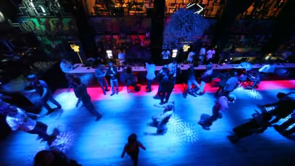 Uitzicht vanaf over op dansen en zit op bar in nachtclub — Stockvideo