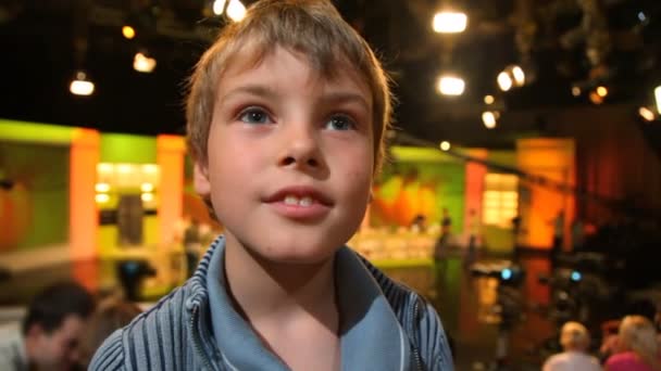 Seyirci ile büyük bir tv stüdyosunda duran çocuk — Stok video