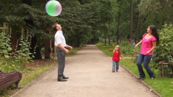 Familia juega algún juego con la pelota en el parque — Vídeos de Stock
