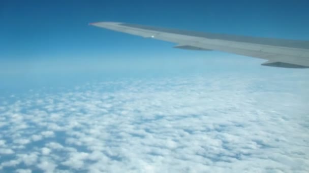 Вид сверху на облака из окна самолета — стоковое видео